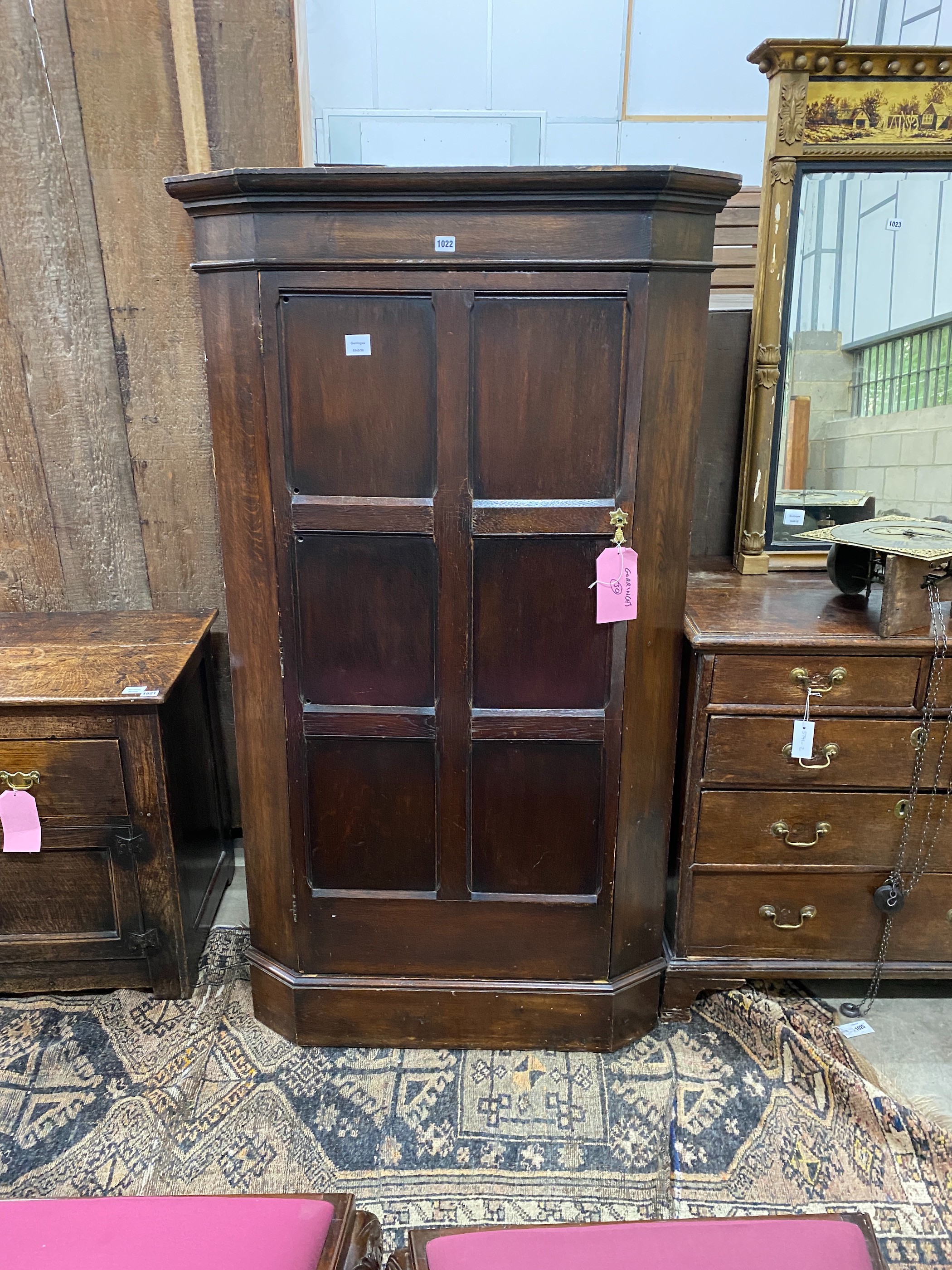 An 18th century style oak standing corner cupboard, enclosed by a full length door, width 94cm, depth 52cm, height 167cm